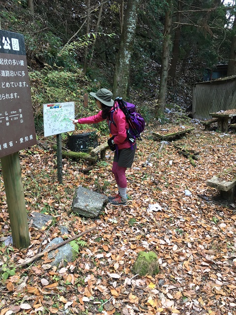 登山口で案内版を確認する女性